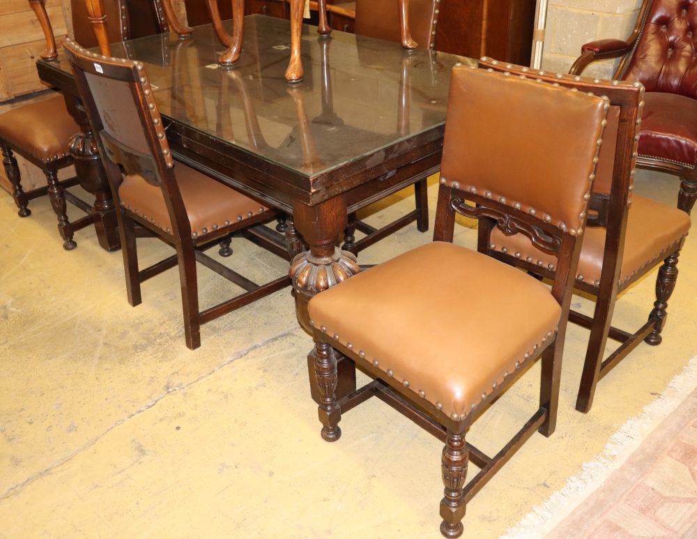 An 18th century style oak draw leaf dining table and a set of six 1920s Jacobean style oak dining chairs, table W.206cm extended, D.99